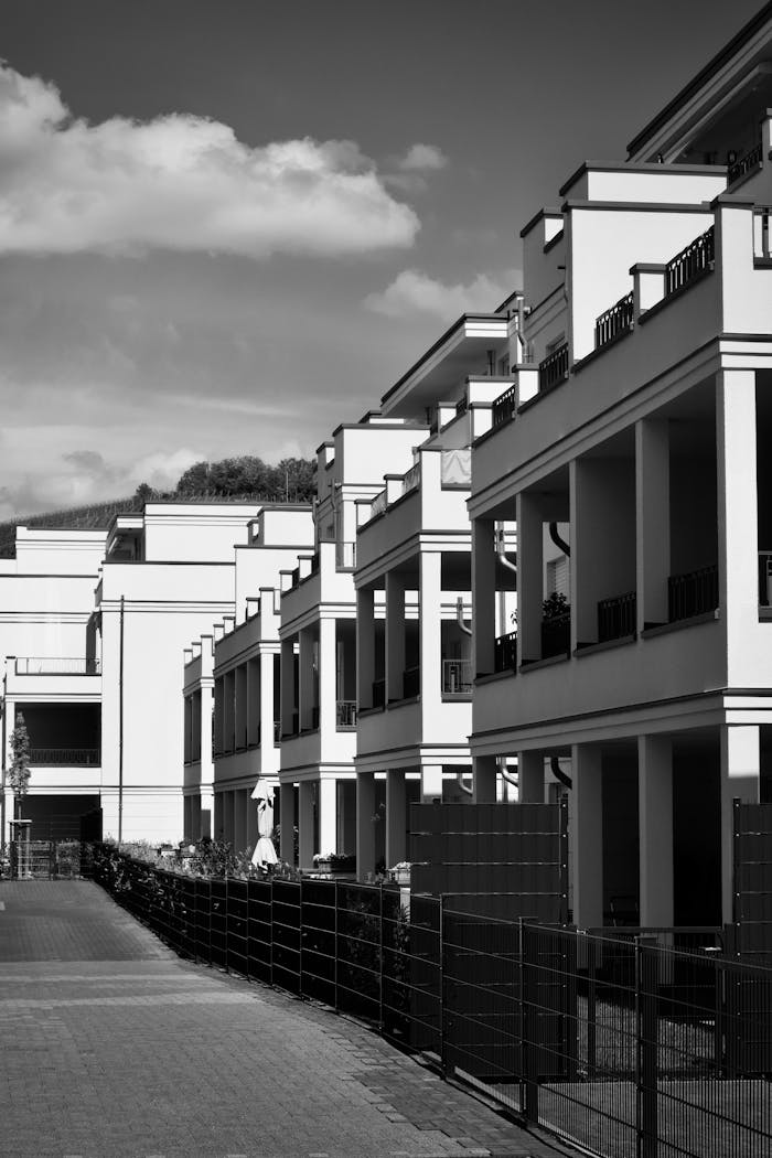 Black and white view of a modern apartment complex under a clear sky.