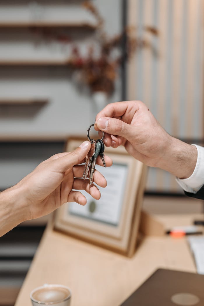 services-03 A real estate agent handing over house keys, symbolizing property ownership transfer.