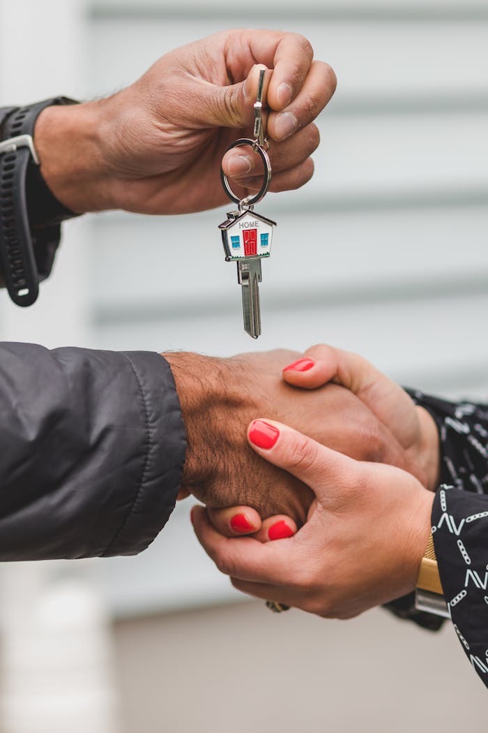 services-01 Close-up of a handshake with a house key, symbolizing real estate transactions.